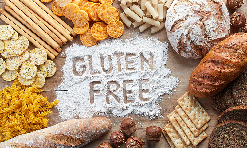 The words "gluten free" spelled in wheat flour on a wooden counter